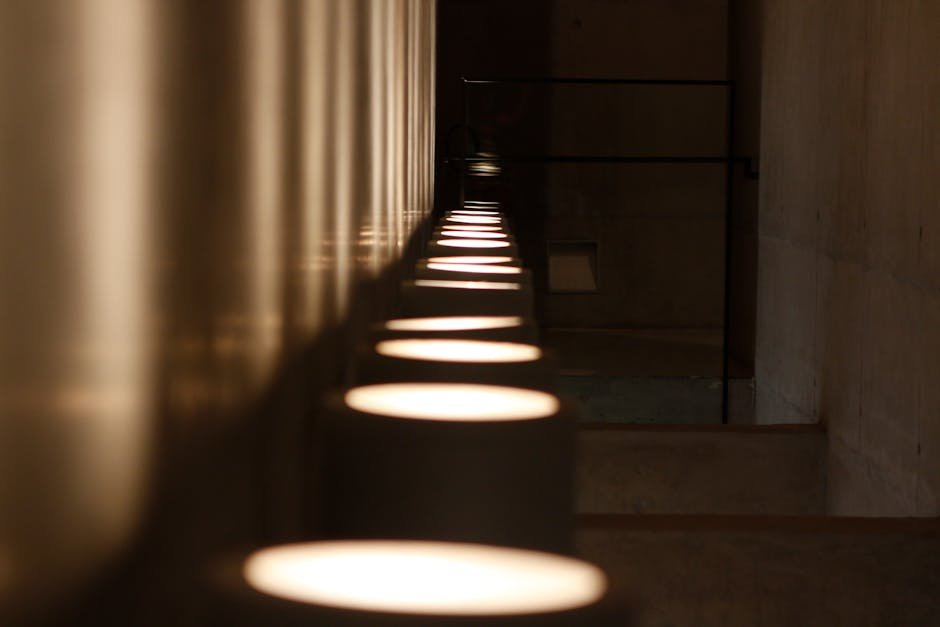 A dark, modern hallway showcasing dramatic lights and reflections on the floor.
